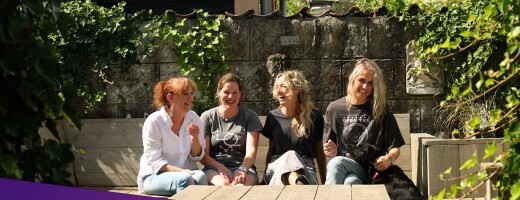 Gea, Mariska, Saskia en Rianne zitten in de tuin en lachen samen.